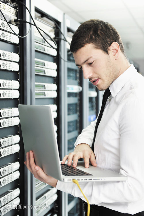 輕的IT工程師與商務(wù)人員 現(xiàn)代鋁制筆記本電腦與網(wǎng)絡(luò)服務(wù)器機(jī)房的融合